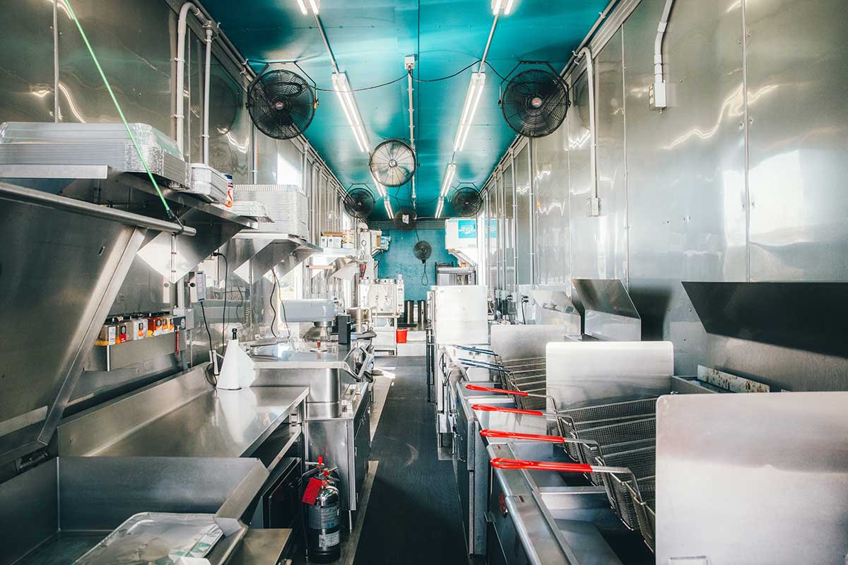 Dining attendant and plates at beginning of food service line.