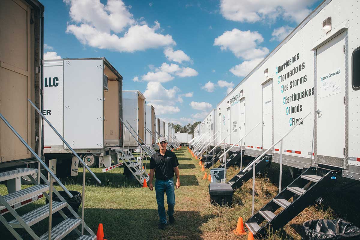 Image of a Team Member walking between sleep trailers.